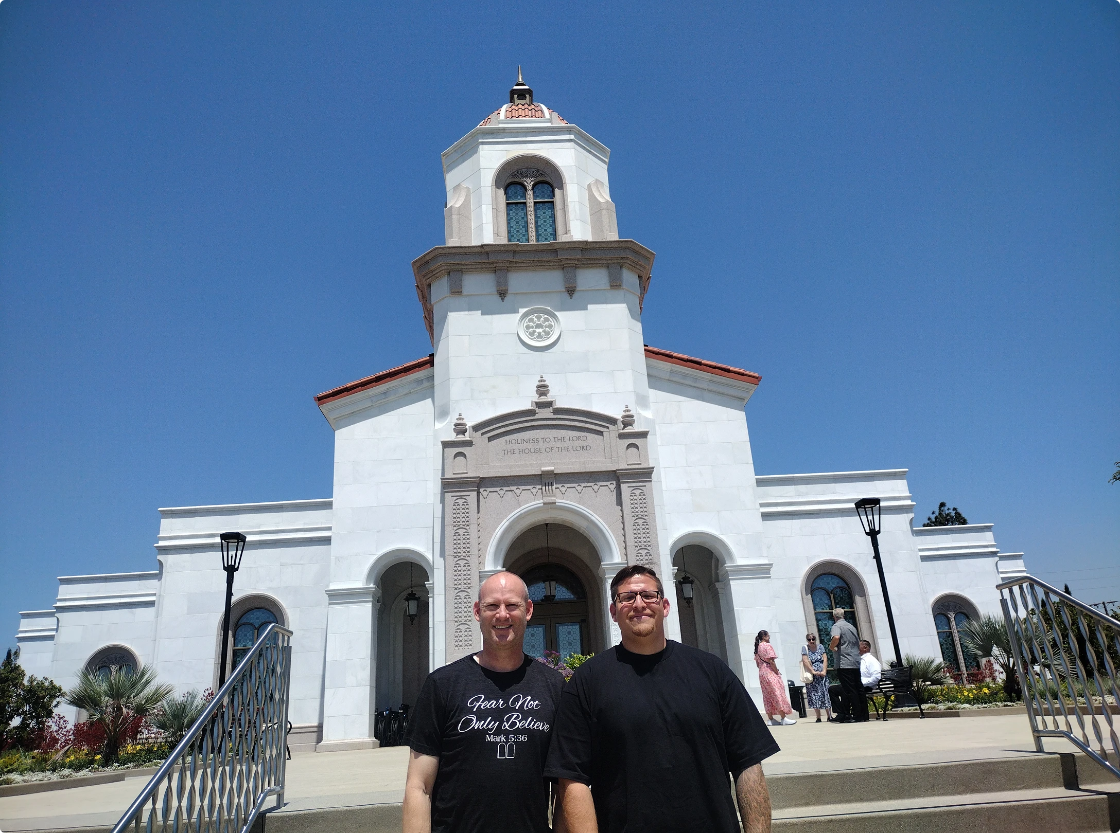 Two people standing in front of church.
