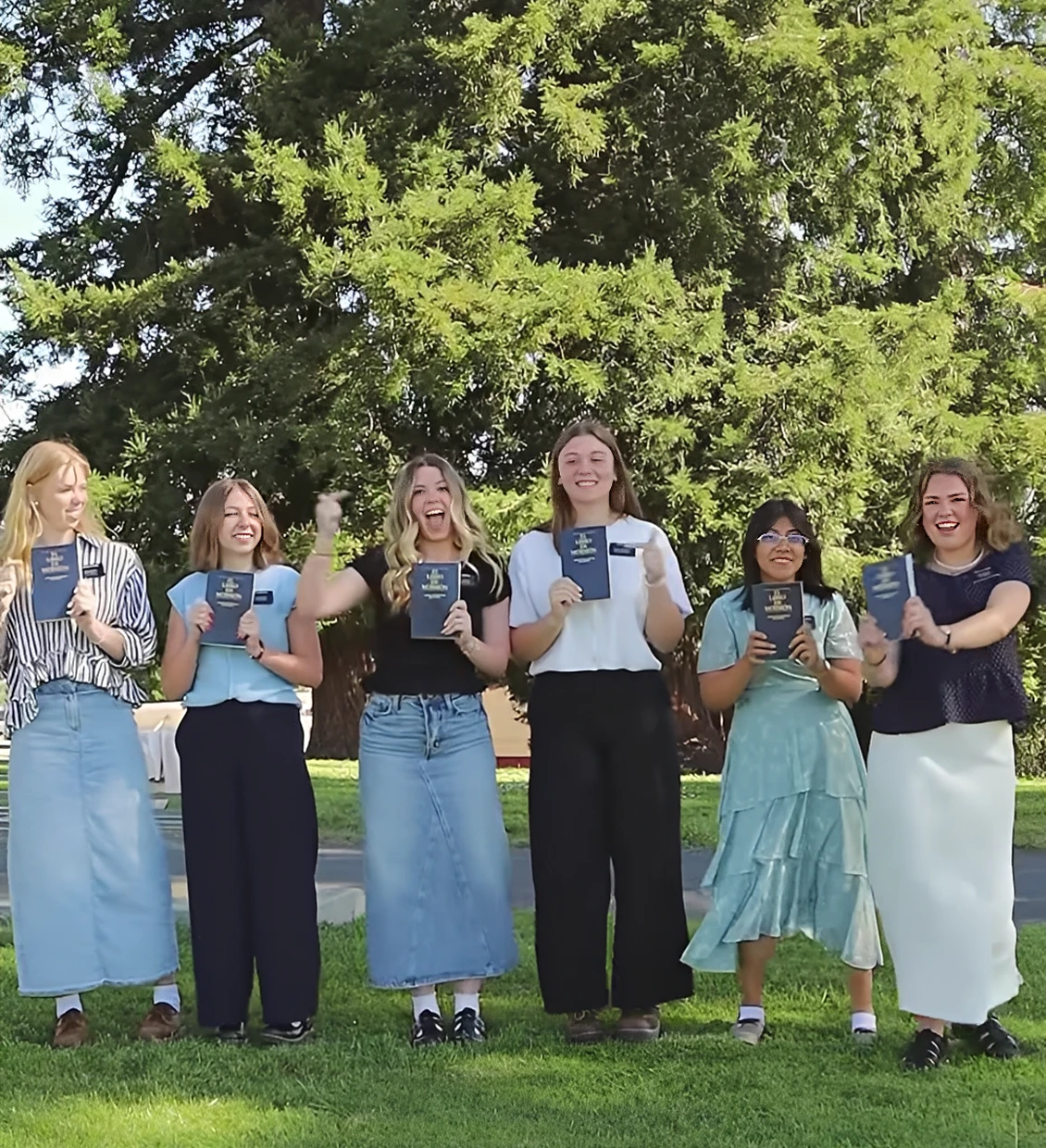 Group of women celebrating outdoors with books.